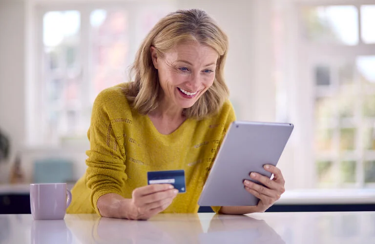 mature-woman-with-credit-card-using-digital-tablet-2023-11-27-04-58-28-utc (1)